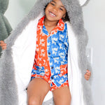 Child wearing a long gray hood with animal ears, standing against a white background.